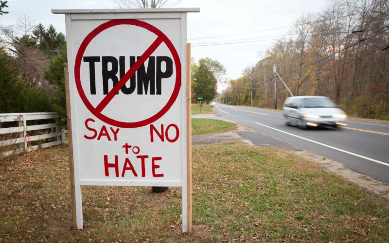 A sign that said "say no to hate" with an X on trump's name