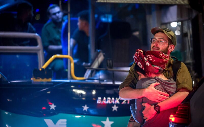 An Israeli reserve soldier kissing goodbye his partner