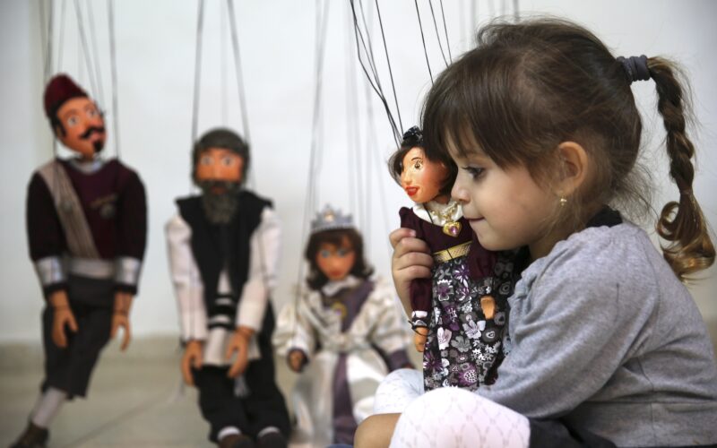 Daughter of Ultra Orthodox artist hugs her favorite marionette doll